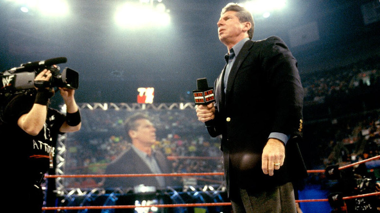 Vince McMahon stands in the ring, shocked, during the segment where he leaves his son, Shane McMahon, purchased WCW during the "Monday Night Wars."