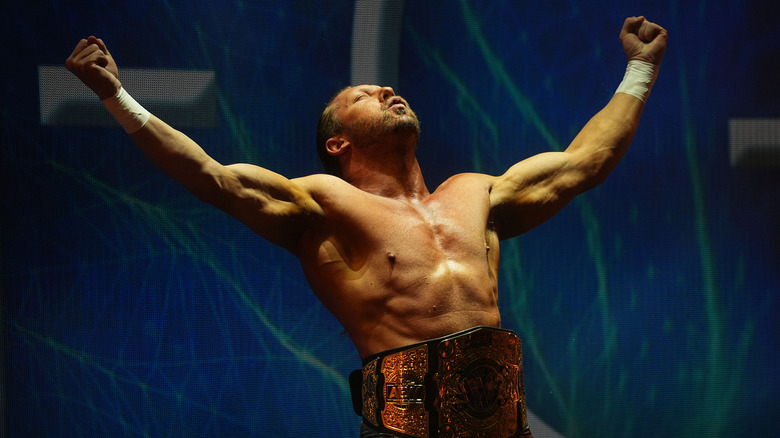 Kenny Omega poses on the stage wearing the International Championship belt before his match with Blake Christian on an episode of "AEW Dynamite."