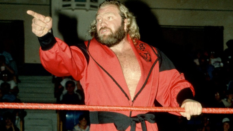 Big John Studd poses for the crowd and points up the ramp before a match.