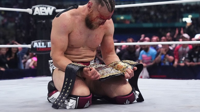 Bryan Danielson on his knees staring down at the AEW World title at All In 2024
