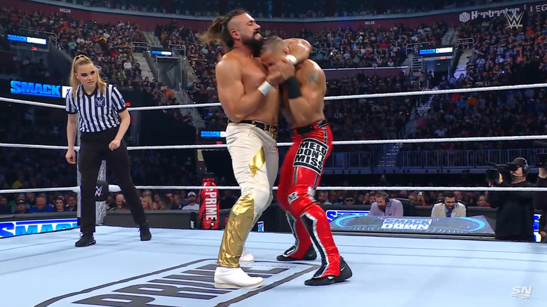 Andrade with a side headlock cinched in on Hayes