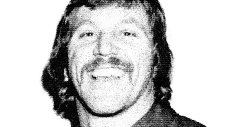 Edward Wiskoski poses for a black-and-white photo, smiling for the camera.