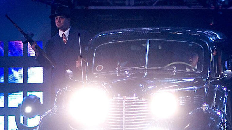 CM Punk makes his unofficial WrestleMania debut as a Chicago mobster with a tommy gun and an old car as part of John Cena's entrance at WrestleMania 22.