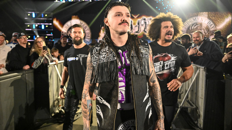 Dominik Mysterio flanked by the Judgment Day