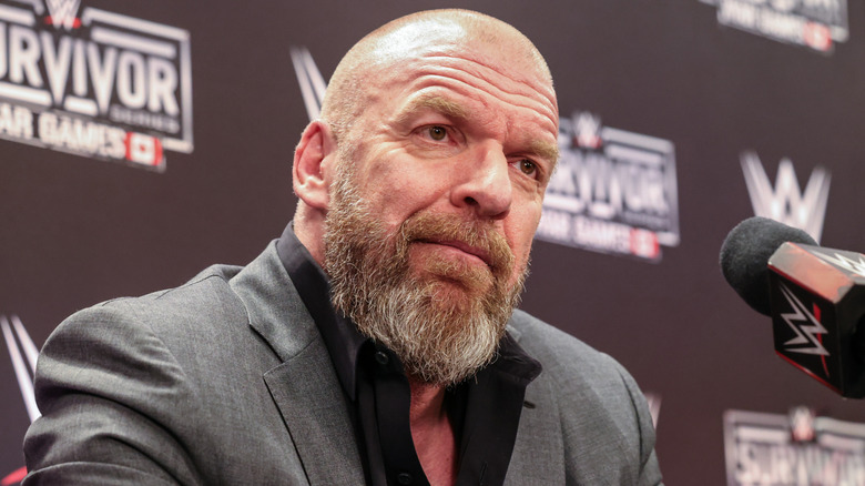 Paul "Triple H" Levesque sitting in front of a WWE microphone