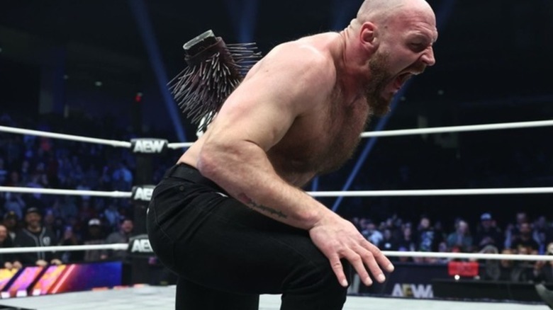 Jon Moxley screaming with a spiked bat stuck in his back