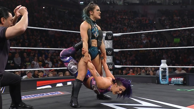 Bayley hangs from Lyra Valkyria's grasp.