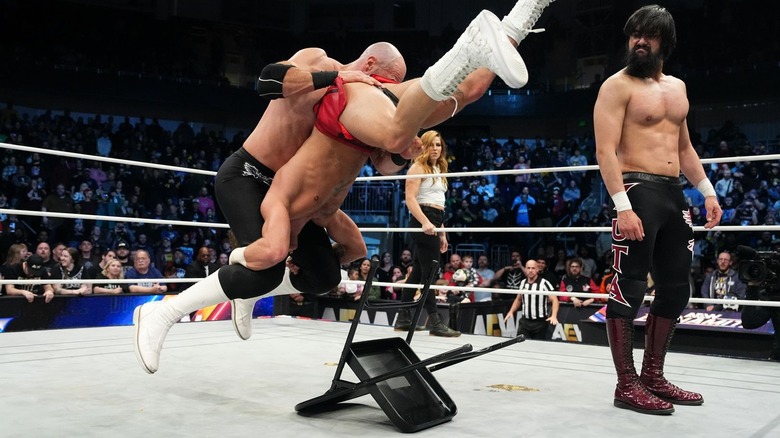Claudio Castagnoli hits a Neutralizer on HOOK on top of a steel chair while Wheeler Yuta looks on on 