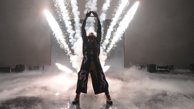 Rey Fenix poses on stage as pyro goes off behind him on "WWE SmackDown"