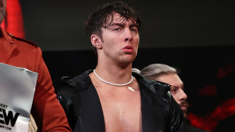Nick Wayne makes his entrance in a black jacket, with Christian Cage just out of frame.