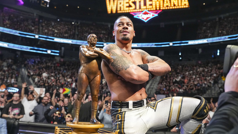 Hayes posing in front of the Andre The Giant trophy