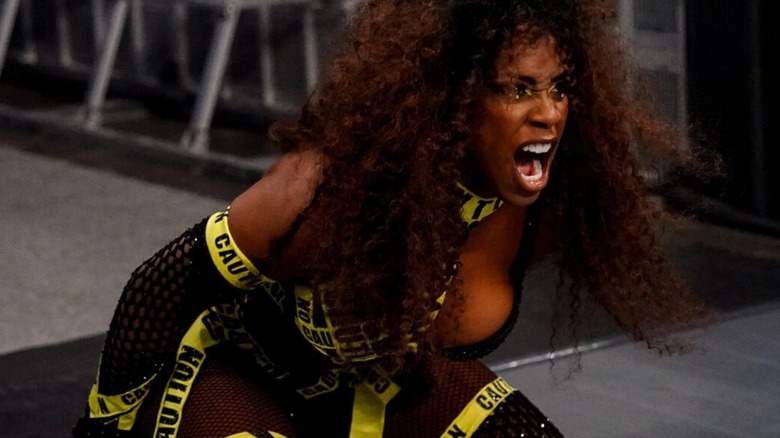 Naomi kneels on the entrance ramp in front of the ring, screaming in frustration at Jade Cargill in the ring during an episode of "WWE SmackDown."