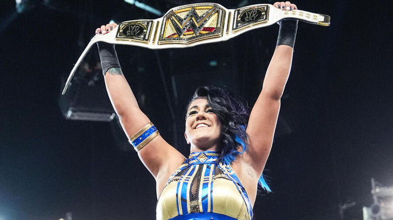 Bayley hoists the WWE Women's Championship above her head.