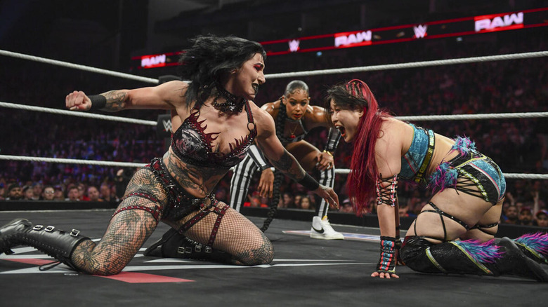 Rhea Ripley throws a punch at IYO SKY as special guest referee Bianca Belair watches on.