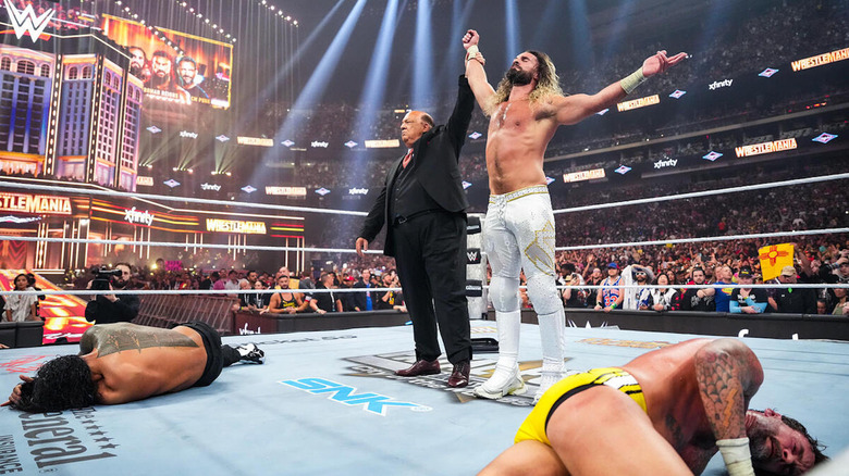 Paul Heyman raises Seth Rollins' arm above the fallen Roman Reigns and CM Punk at WWE WrestleMania 41