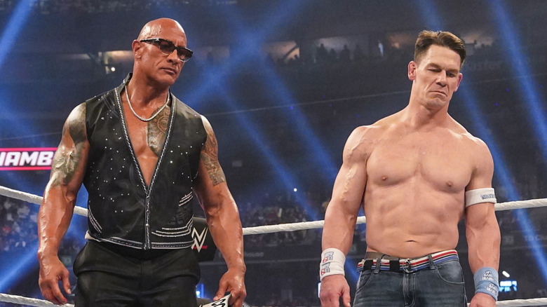 Dwayne "The Rock" Johnson and John Cena stand over Cody Rhodes during WWE Elimination Chamber at Rogers Centre on March 1, 2025 in Toronto, Canada.