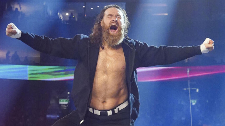 Sami Zayn cheers as he perches himself on the top rope.