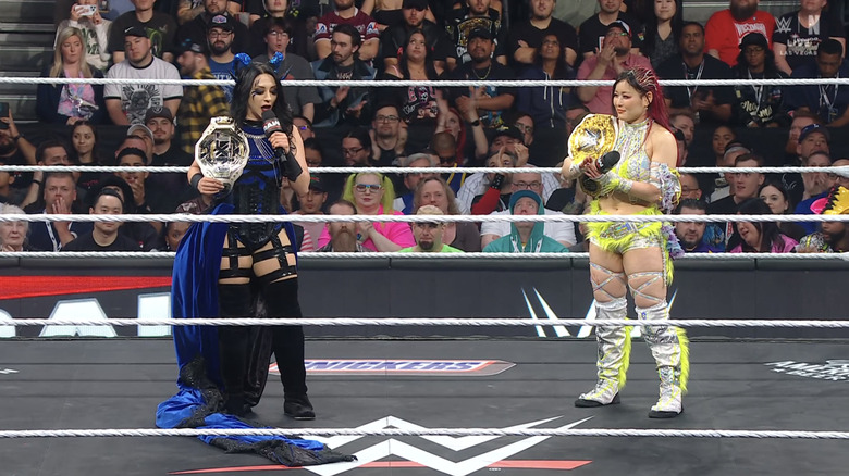 Stephanie Vaquer holds the NXT Women's Championship as she speaks on the microphone to WWE Women's World Champion IYO SKY.