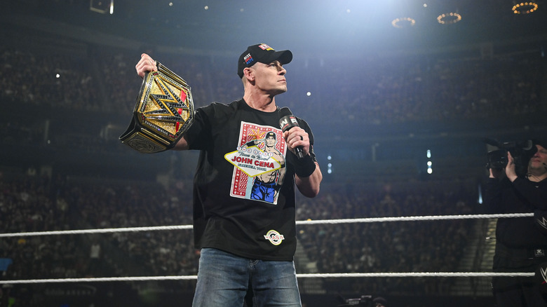John Cena holds up WWE title belt in the middle of the ring on 