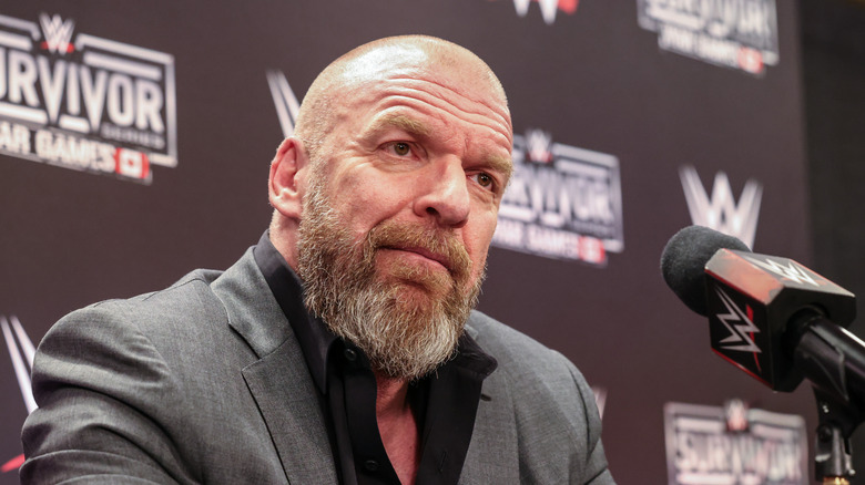 Paul Triple H Levesque talking at microphone at Survivor Series in Vancouver.