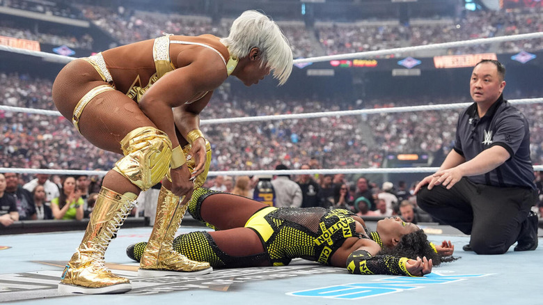 Jade Cargill stands over a downed Naomi as referee Ryan Tran attempts to defuse the situation.
