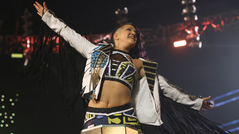 Bayley poses to the crowd on the middle rope before a scheduled match