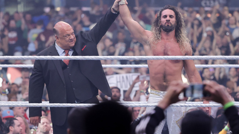 Paul Heyman raising Seth Rollins' arm