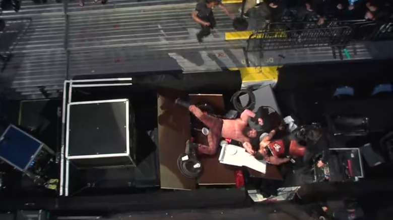 Strowman and Fatu after being suplexed off the roadcase and through the tables
