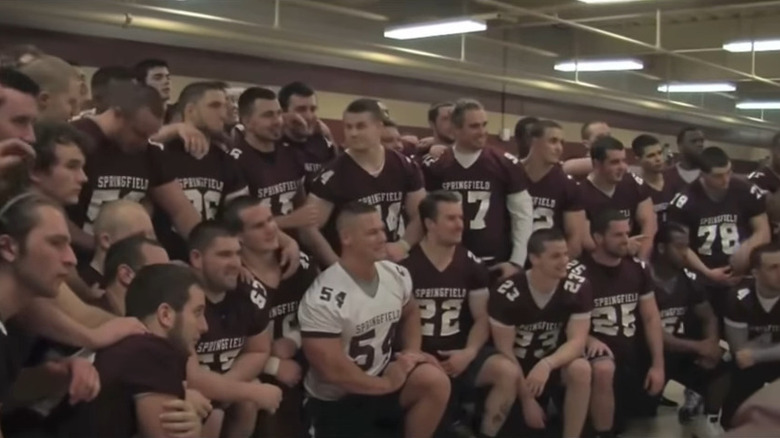 John Cena surrounded by football team
