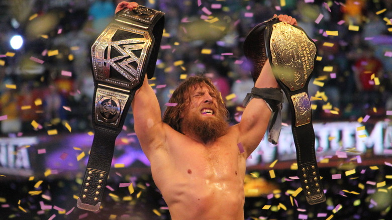 Daniel Bryan holding two belts