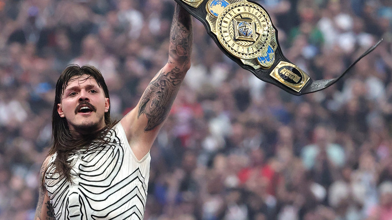 Dominik Mysterio holds the WWE Intercontinental Title high