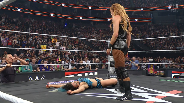 Becky Lynch stands over a downed Lyra Valkyria, menacingly.