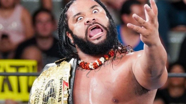 Jacob Fatu poses with the MLW World Heavyweight Championship in the ring before a match.