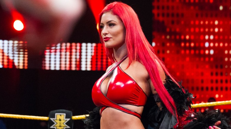 Eva Marie stands in the ring in "WWE NXT" taking off her entrance robe before a match.