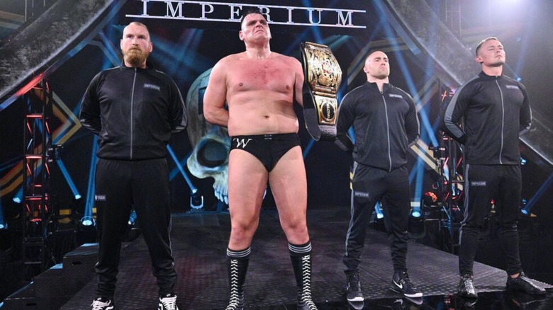 GUNTHER holds the NXT UK Championship on the stage alongside his fellow Imperium stablemates after a successful title defense.