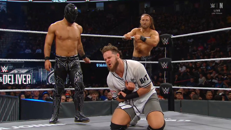 Axiom and Walker in the ring as Frazer watches from the apron