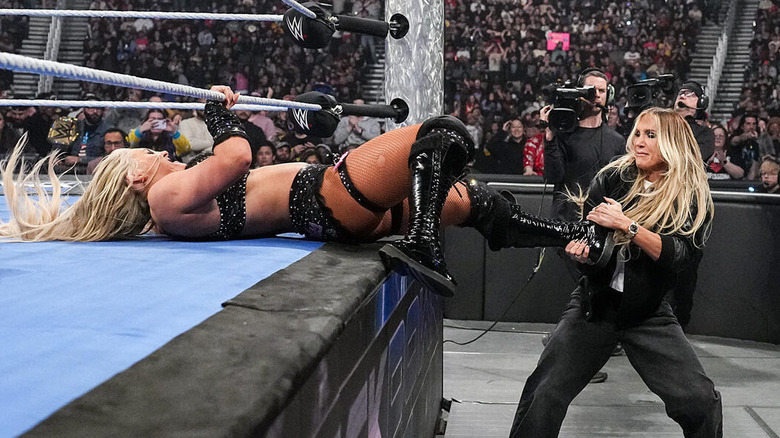 Charlotte Flair grabs the ankle of WWE Women's Champion Tiffany Stratton as she drags her out of the ring during a brawl on "WWE SmackDown."