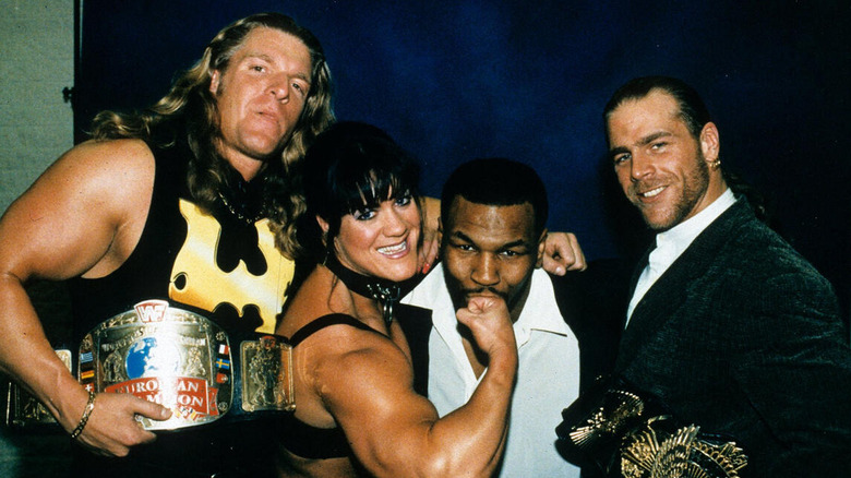 Triple H, Chyna, and Shawn Michaels pose with Mike Tyson backstage.
