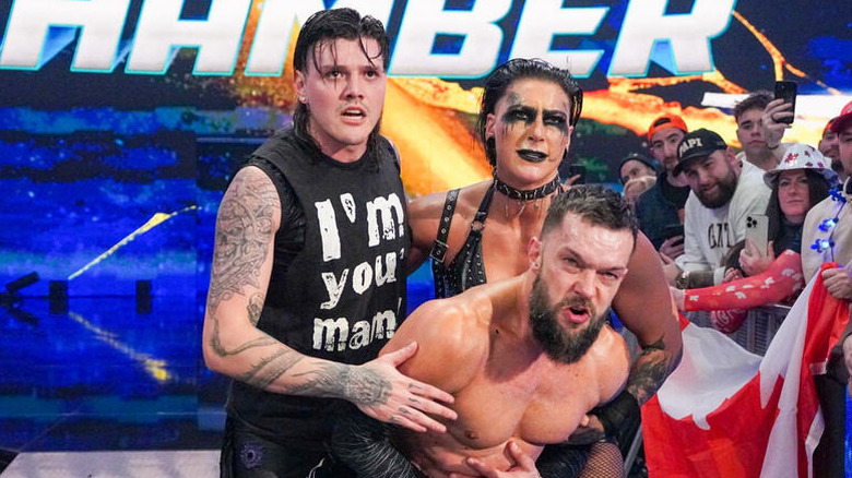 Dominik Mysterio and Rhea Ripley hold Finn Balor on the ramp and look tot he ring following a match on WWE progrmaming.
