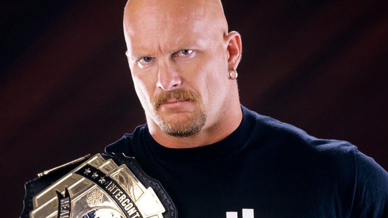 "Stone Cold" Steve Austin poses for the camera holding the WWF Intercontinental Championship belt.