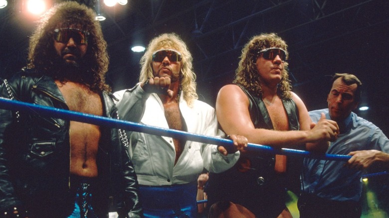 The Fabulous Freebirds pose on the ropes alongside a referee before a match on WWF programming.