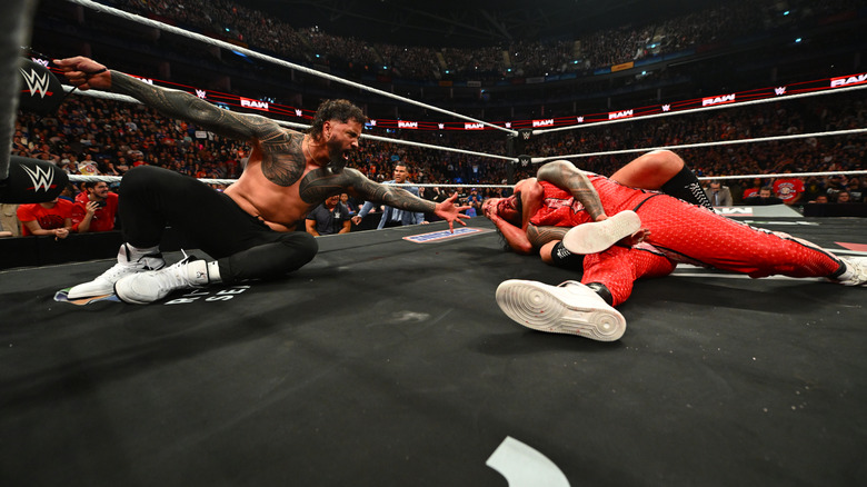 Gunther chokes out Jimmy Uso as Jey Uso watches