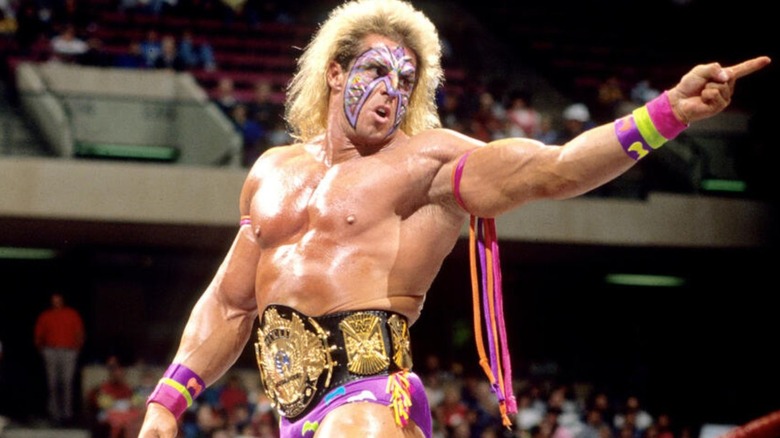 Ultimate Warrior points to the fans while posing in the ring before a match.
