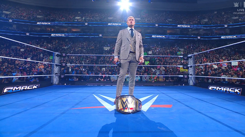 Rhodes standing over his Undisputed WWE Championship