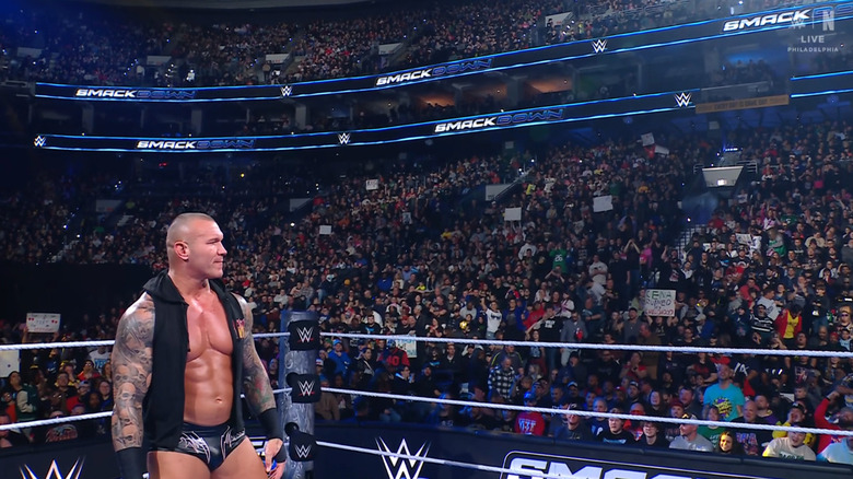 Orton standing in the ring with fans behind him