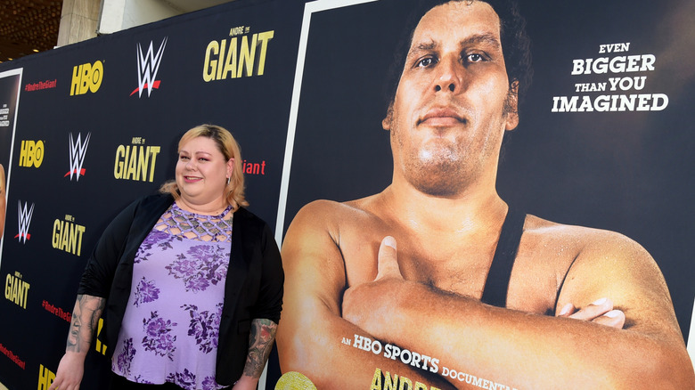 Robin Christensen-Roussimoff posing next to a picture of Andre the Giant
