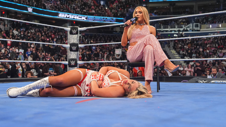 Charlotte Flair sits in the ring with Tiffany Stratton