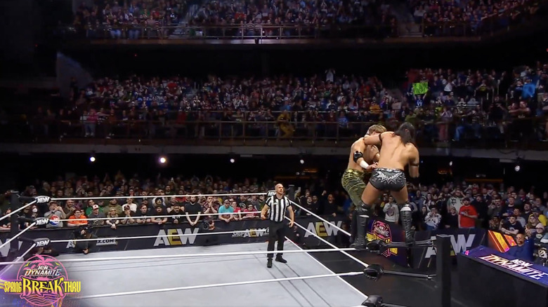 Ospreay and Takeshita teetering on the ropes