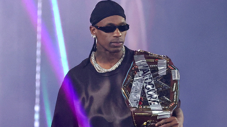 Travis Scott holding a replica championship belt