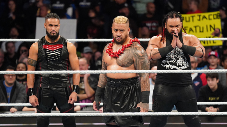 Tama Tonga; Solo Sikoa and Jacob Fatu make their entrance during Friday Night SmackDown at XL Center on December 13, 2024 in Hartford, Connecticut.